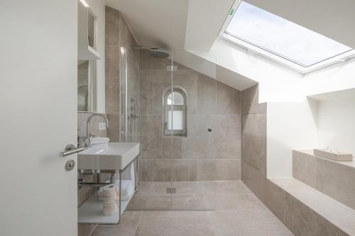 a bathroom with a sink and a shower with a window at Apartments Hotel Stadt Hamburg in Westerland (Sylt)