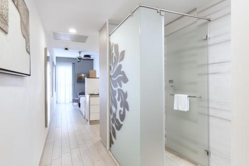 baño con ducha y puerta de cristal en Hotel Riu Palace Tenerife, en Adeje