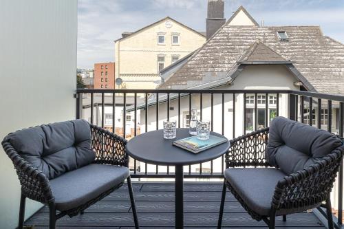 a balcony with two chairs and a table on a balcony at Apartments Hotel Stadt Hamburg in Westerland (Sylt)