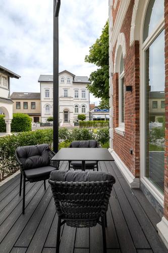 a patio with a table and chairs on a deck at Apartments Hotel Stadt Hamburg in Westerland (Sylt)