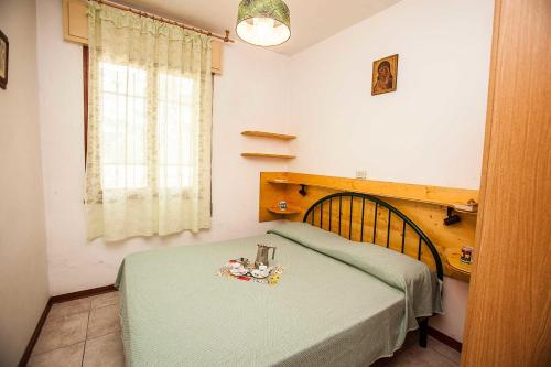 Un dormitorio con una cama con una manta verde. en Quiet little villa by the seaside in Rosolina Mare, en Rosolina Mare