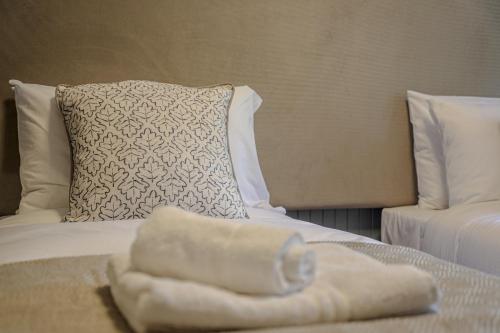 a pile of towels on a bed with a pillow at Bridge End Hotel in Llangollen