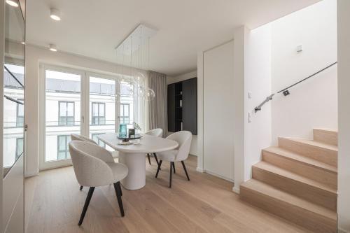 a white dining room with a white table and chairs at Apartments Hotel Stadt Hamburg in Westerland (Sylt)