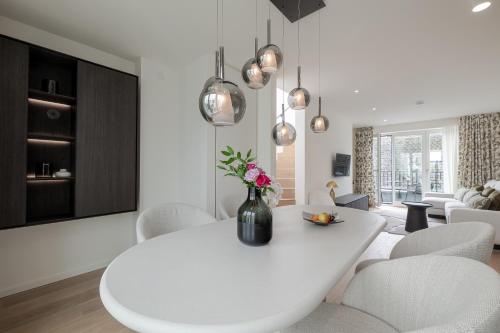 a white dining room with a white table and chairs at Apartments Hotel Stadt Hamburg in Westerland (Sylt)