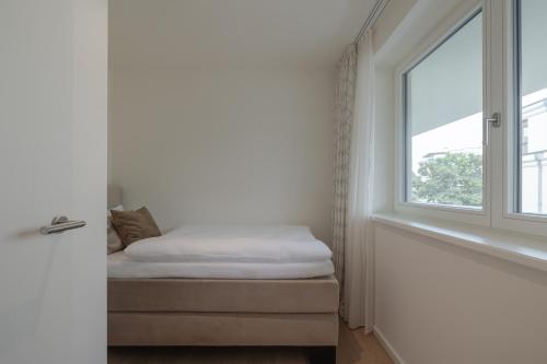a bedroom with a bed and a window at Apartments Hotel Stadt Hamburg in Westerland (Sylt)