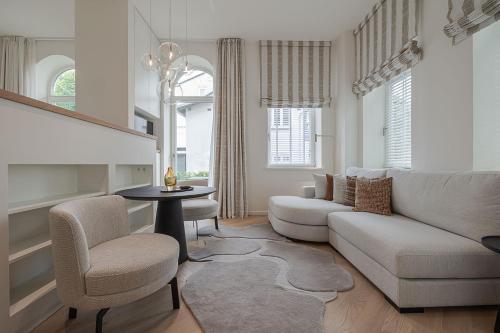a living room with a couch and a table and chairs at Apartments Hotel Stadt Hamburg in Westerland (Sylt)