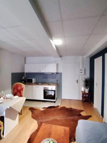 un salon avec une table et une cuisine dans l'établissement T2 N7 Appartement Hôtel Combes, à Amélie-les-Bains-Palalda