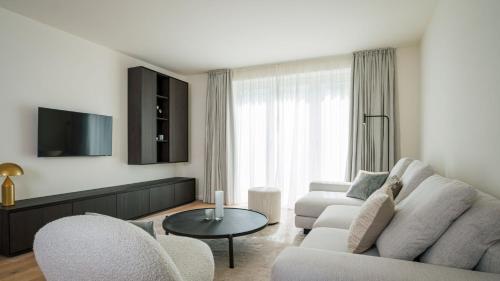 a living room with a couch and chairs and a tv at Apartments Hotel Stadt Hamburg in Westerland (Sylt)