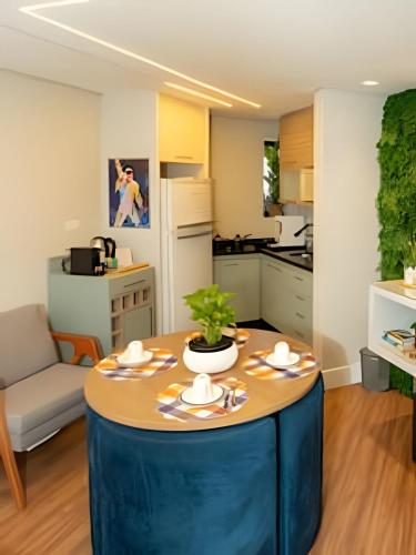a kitchen and living room with a table with a plant on it at Lindo flat na Sena Madureira! (Apto 1305) in Sao Paulo