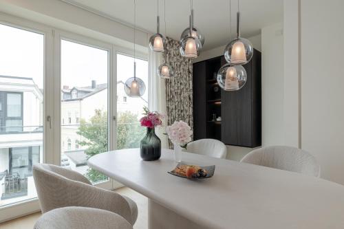 a white dining room with a white table and chairs at Apartments Hotel Stadt Hamburg in Westerland (Sylt)