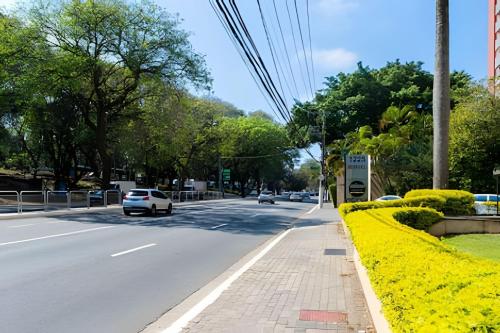 a street with cars driving down a road with yellow flowers at Lindo flat na Sena Madureira! (Apto 1305) in Sao Paulo