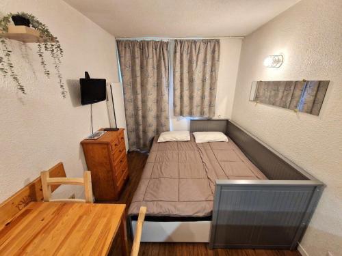 une petite chambre avec un lit et une table dans l'établissement Studio rénové 2-3 personnes à Valfréjus, balcon et vue piste - FR-1-265-229, à Valfréjus