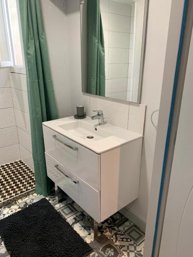 une salle de bain avec un lavabo blanc et un miroir dans l'établissement Rue de la paix, à Mont-de-Marsan