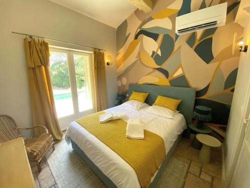 une chambre avec un lit avec un tableau sur le mur dans l'établissement Mazet Rigodon Alpilles, à Eygalières