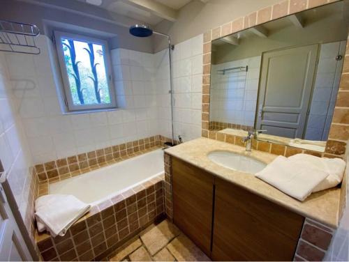 une salle de bain avec une baignoire, un lavabo et un miroir dans l'établissement Mazet Rigodon Alpilles, à Eygalières
