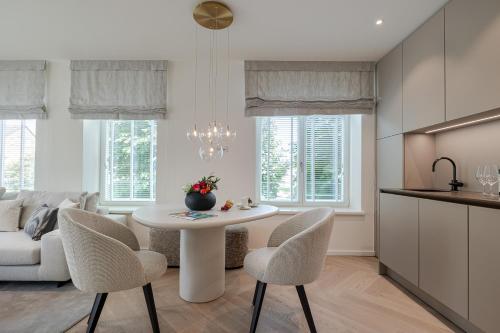 a kitchen and living room with a white table and chairs at Apartments Hotel Stadt Hamburg in Westerland (Sylt)