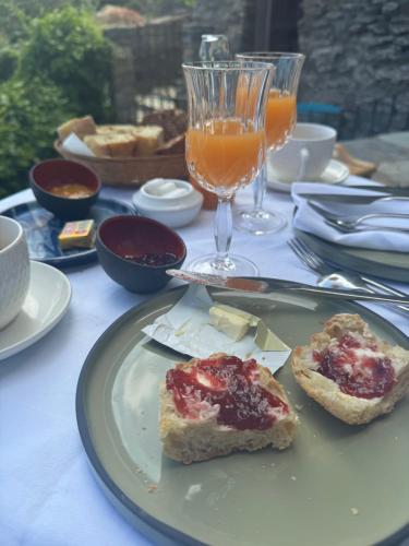 a table with a plate with two slices of bread and drinks at Torra di Ciocce in Pino