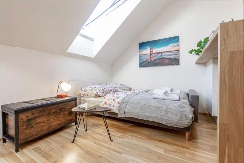 um quarto com uma cama e uma clarabóia em Minimalist's Dream - sunny cozy studio in New Town em Praga