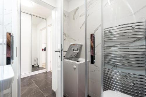 um banheiro branco com uma pia e um espelho em Minimalist's Dream - sunny cozy studio in New Town em Praga