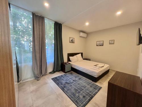a bedroom with a bed and a large window at Kiara Apartments in Saints Constantine and Helena