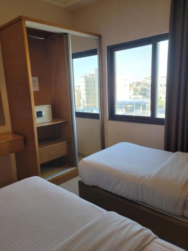 a hotel room with two beds and a window at Big Ben Hotel Suites in Amman