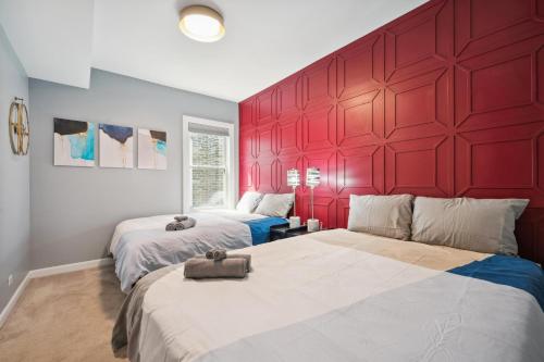 two beds in a room with a red wall at Wrigley 2BR, 1BA with Free Parking in Chicago