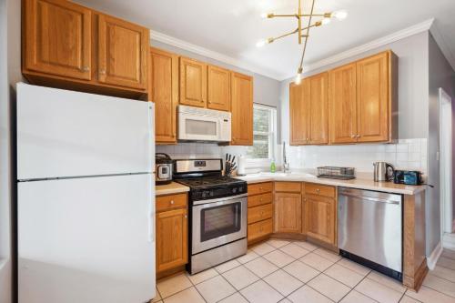 a kitchen with wooden cabinets and a white refrigerator at Wrigley 2BR, 1BA with Free Parking in Chicago