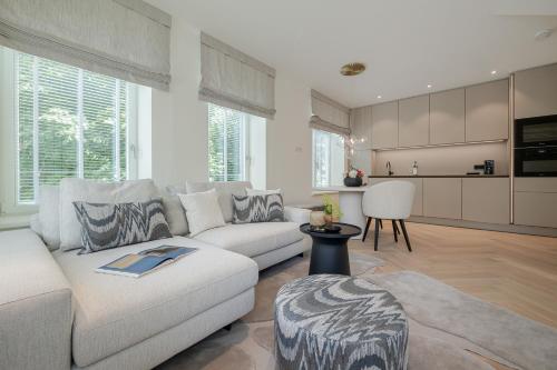 a living room with a white couch and a kitchen at Apartments Hotel Stadt Hamburg in Westerland (Sylt)