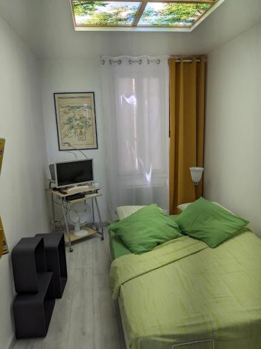 une chambre avec un lit et un bureau avec un ordinateur dans l'établissement joli studio T2 meublé de 20 m² Située à 2 minutes à pied du MÉTRO, à Marseille