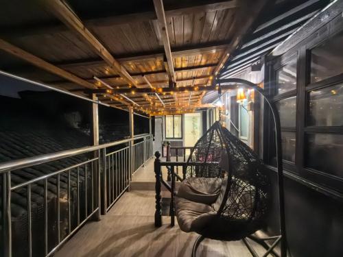 a porch with a hammock on the side of a train at 西塘明清雕花大院尊闻堂百寿厅庭院民宿 in Jiashan