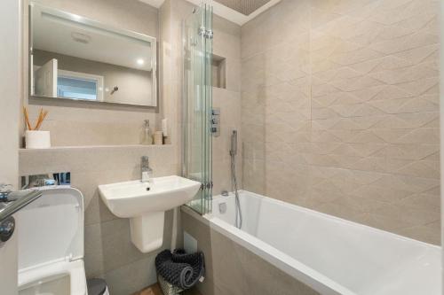 a bathroom with a sink and a bath tub and a sink at Derwentwater View in Portinscale