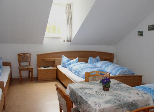 ein Schlafzimmer mit einem Bett und einem Tisch mit blauen Kissen in der Unterkunft Hotel Bayerischer Hof in Wiesau