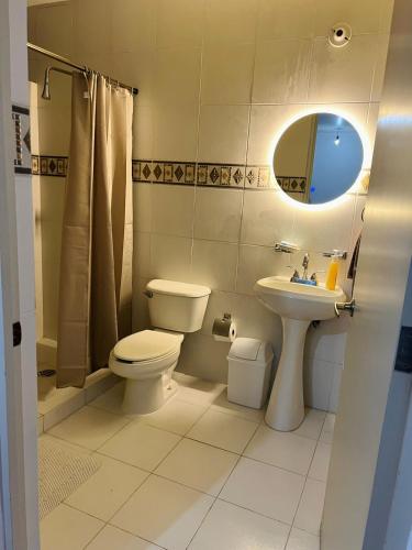a bathroom with a toilet and a sink and a mirror at Hermoso con vista increíble in Mexico City
