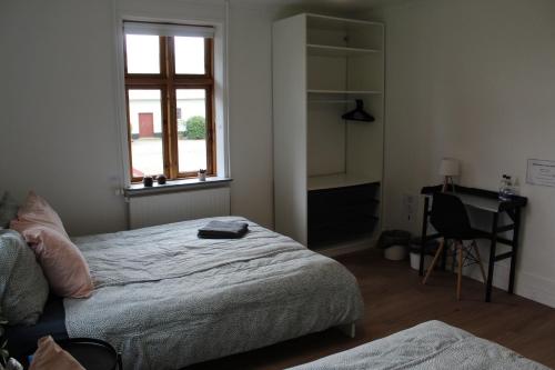 a bedroom with a bed and a desk and a window at STAY Billund in Vandel