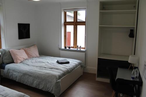 a small bedroom with a bed and a window at STAY Billund in Vandel