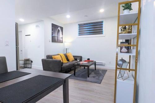 a living room with a couch and a table at Cozy 1-Bedroom Basement Suite in Rosewood in Saskatoon
