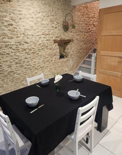 a black table with bowls on it in a room at Maison près de la mer , les plages du débarquement in Courseulles-sur-Mer