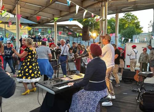 a woman playing a keyboard in a crowd of people at Maison près de la mer , les plages du débarquement in Courseulles-sur-Mer