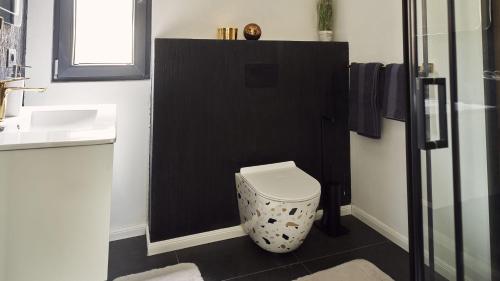 a bathroom with a white toilet and a sink at Blissful Resort - Valea Doftanei in Teşila