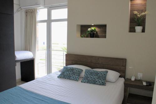 a bedroom with a bed with blue and white pillows at Charming and Family With a pool and ocean view, 3 blocks from the beach, with 2 TVs and Netflix in Boca del Río