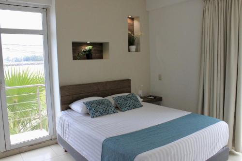 a bedroom with a bed and a large window at Charming and Family With a pool and ocean view, 3 blocks from the beach, with 2 TVs and Netflix in Boca del Río