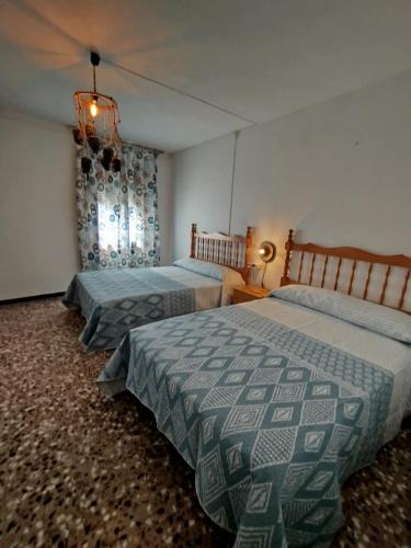 a bedroom with two beds and a window at casa eras irene in Moratalla