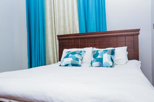 a bedroom with a bed with blue curtains at Yo House Muyenga in Muyenga 