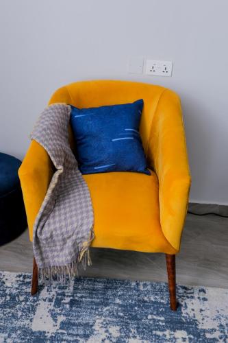 a yellow couch with a blanket on top of it at Yo House Muyenga in Muyenga 