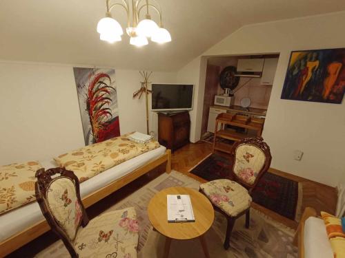 ein Wohnzimmer mit Sofa, Tisch und Stühlen in der Unterkunft Stara Ruža in Gračanica