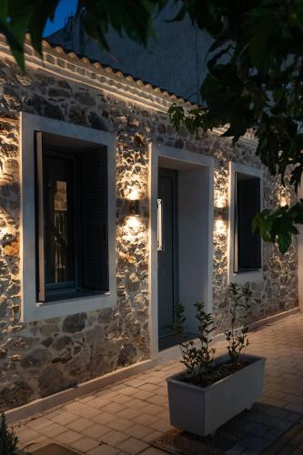 a stone house with lights on the side of it at Centro Stone House in Tolo