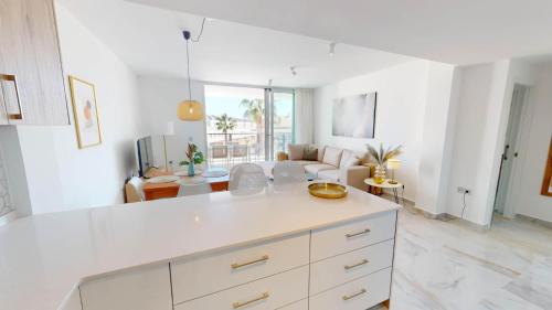 a kitchen with white cabinets and a living room at Casa Virginia in Los Alcázares
