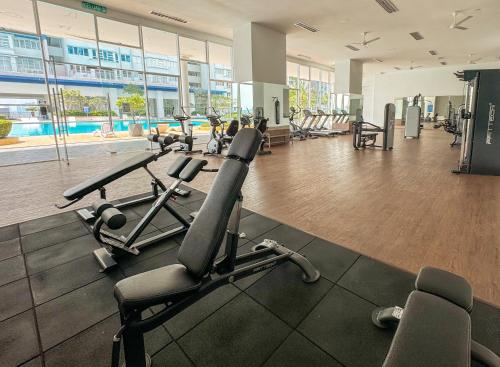 a gym with treadmills and ellipticals in a building at Palmera Residence Cozy Condo in Kajang