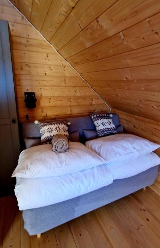 a bed in a room with a wooden ceiling at Góralskie Izby, Dom z Balią, Jacuzzi i Sauną in Koniaków