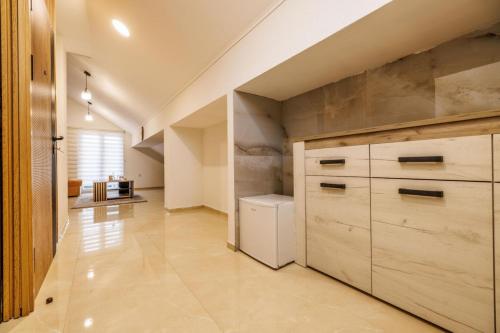 a kitchen with wooden cabinets and a large appliance at Hotel Mažijanik in Nikšić